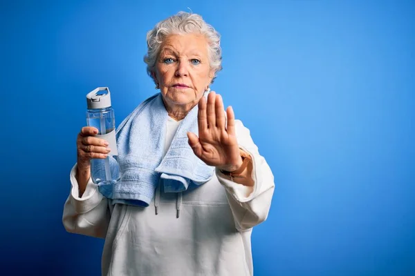 Senior Bela Mulher Desportiva Segurando Garrafa Água Sobre Fundo Azul — Fotografia de Stock