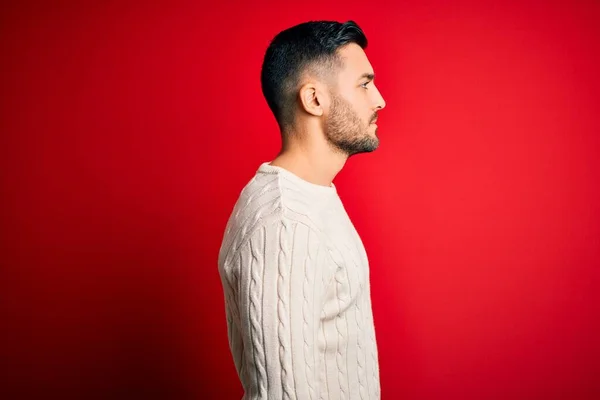 Jovem Homem Bonito Vestindo Camisola Branca Casual Sobre Fundo Vermelho — Fotografia de Stock