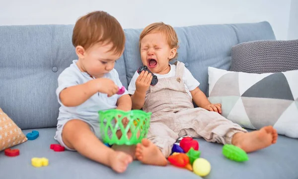 Vackra Småbarn Dem Gråter Sitter Soffan Och Leker Med Leksaker — Stockfoto