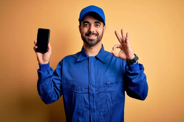 Μηχανικός Άνθρωπος Γενειάδα Φορώντας Μπλε Στολή Και Καπάκι Κρατώντας Smartphone — Φωτογραφία Αρχείου