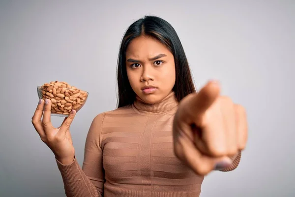 Genç Asyalı Kız Elinde Sağlıklı Fıstıklarla Beslenme Için Beyaz Arka — Stok fotoğraf