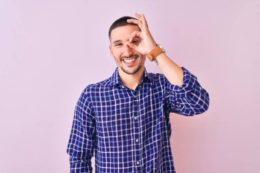 Genç yakışıklı adam izole edilmiş arka planda duruyor. El hareketleriyle gülümsüyor, gözleriyle mutlu yüzlere bakıyor..