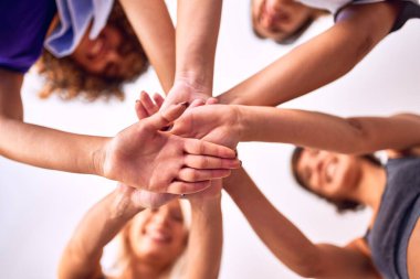 Spor salonunda yoga dersinden sonra el sıkışan genç ve güzel bir kadın grubu.
