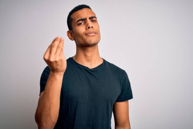 Beyaz arka planda dikilen ve elleri ve parmakları kendinden emin ifadesiyle İtalyan jestleri yapan gündelik tişörtler giyen Afro-Amerikan genç adam.