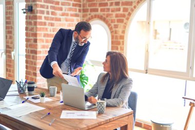 İki orta yaşlı iş adamı birlikte çalışıyor. Ofisteki kadına zorbalık yapan adam.
