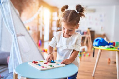 Anaokulunda matematik oyunu oynayan genç ve güzel bir çocuk.