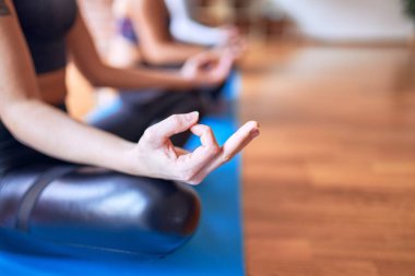 Genç ve güzel bir grup sporcu kadın yoga yapıyor. Spor salonunda nilüfer pozu veriyorum.