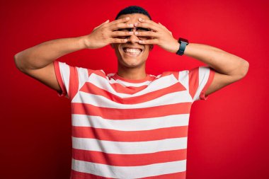 Genç, yakışıklı, Afro-Amerikalı bir adam, günlük çizgili tişört ve gözlük takıyor, gözleri kapatıyordu, neşeli ve komik gülümsüyordu. Kör kavram.