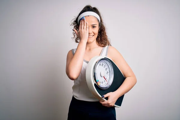 Kıvırcık Saçlı Genç Bir Kadın Beyaz Arka Planda Tartı Makinesi — Stok fotoğraf