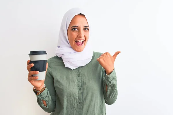 若いです美しいですアラブ女性身に着けています伝統的なイスラム教徒のヒジャーブコーヒーを飲みます指すと幸せな顔笑顔で親指で側面まで表示 — ストック写真