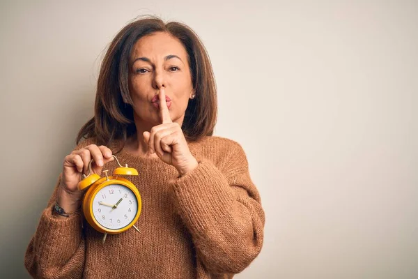 Brunetka Średnim Wieku Trzymająca Klasyczny Budzik Odosobnionym Tle Prosząca Ciszę — Zdjęcie stockowe