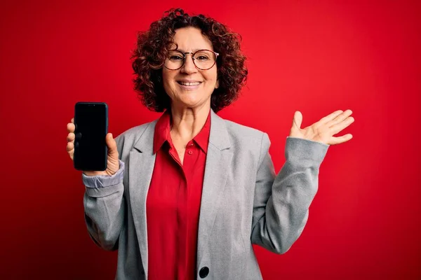Lockige Frau Mittleren Alters Mit Smartphone Bildschirm Vor Rotem Hintergrund — Stockfoto