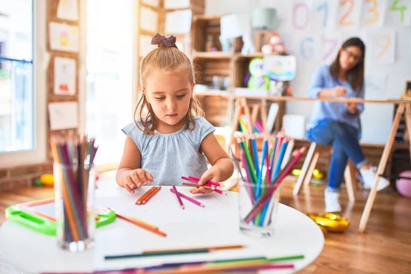 白人女孩在学校和女教师一起玩和学习 母亲和女儿在游戏室里围着铅笔色的玩具作画 — 图库照片