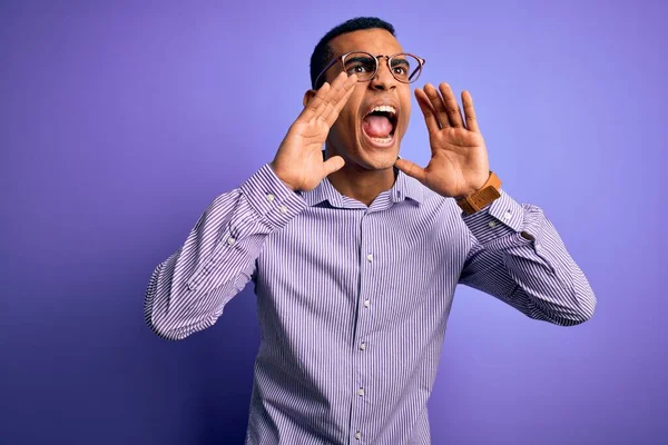 Przystojny Afroamerykanin Pasiastej Koszuli Okularach Fioletowym Tle Krzyczący Wściekły Rękami — Zdjęcie stockowe