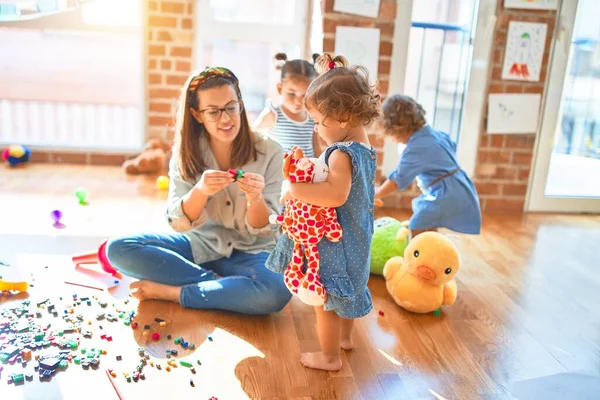 Mooie Leraar Groep Peuters Spelen Rond Veel Speelgoed Kleuterschool — Stockfoto