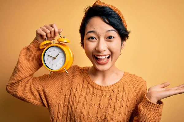 Ung Vacker Kinesisk Kvinna Håller Vintage Väckarklocka Över Isolerad Gul — Stockfoto