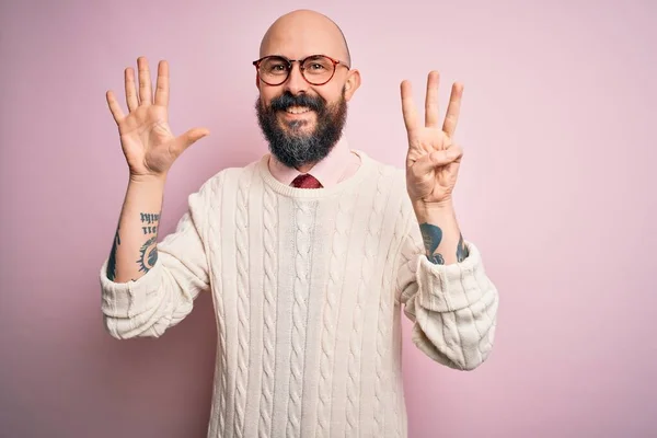 Przystojny Łysy Mężczyzna Brodą Tatuażem Okularach Swetrze Różowym Tle Pokazując — Zdjęcie stockowe