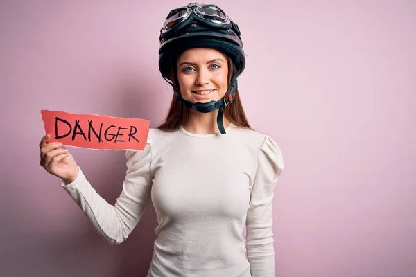 青い目をした美しいバイク乗りの女性は 顔が幸せで笑顔が自信を持って歯を見せてくれる危険なメッセージを持っている元ヘルメットを身に着けている — ストック写真