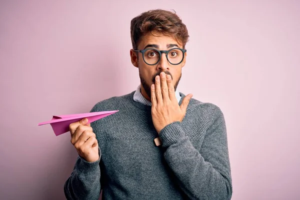 Mladý Pohledný Muž Drží Papírové Letadlo Nosí Brýle Přes Izolované — Stock fotografie