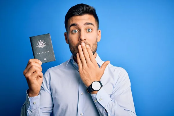 Mladý Pohledný Turista Australským Cestovním Pasem Modrém Pozadí Zakrývá Ústa — Stock fotografie
