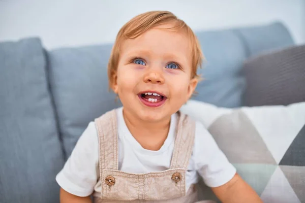 Adorable Niño Rubio Sentado Sofá Sonriendo Feliz Casa —  Fotos de Stock