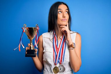 Genç, güzel, esmer, başarılı, madalyalar takan, ciddi yüzler takan, soru soran, kafası karışık bir kadın.