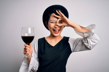 Genç, güzel Asyalı şarap garsonu kız izole edilmiş beyaz arka planda bir bardak kırmızı şarap içerken gülümseyen bir gülümseme.