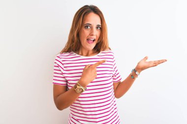 Genç kızıl saçlı kadın, çizgili günlük tişört giyiyordu. İzole edilmiş beyaz bir arka plan üzerindeydi. Kameraya hayret ediyor ve gülümsüyordu..