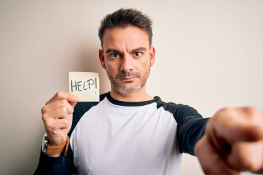 Genç yakışıklı adam, hatırlatma kağıdını elinde tutarken kameraya ve sana işaret eden el işareti ile ön taraftan olumlu ve kendinden emin bir jest yaptığını vurguladı.