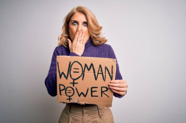 Orta yaşlı güzel sarışın kadın kadın kadın hakları istiyor pankartı tutuyor ağzı kapalı bir şekilde hata yaptığı için utanmış, korku ifadesi, sessizlikten korkmak, gizli konsept