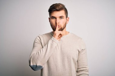 Sakallı, mavi gözlü, sıradan süveter giyen, dudakları parmaklı, sessiz olmak isteyen genç, yakışıklı sarışın bir adam. Sessizlik ve gizli konsept.