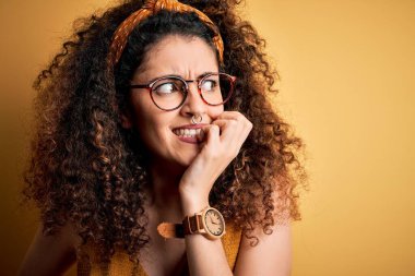 Güzel esmer kadın tatilde. Kıvırcık saçlı ve piercing takıyor. Gözlük takıyor. Endişe sorunu.