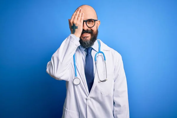 ハンサムなはげ医者男とともにひげを生やして眼鏡と聴診器上の青の背景カバー一つ目で手 自信満面の笑顔と驚きの感情 — ストック写真