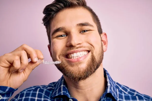 Jonge Blonde Man Met Baard Blauwe Ogen Houden Tandheelkundige Uitlijning — Stockfoto