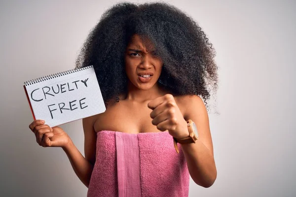 Young african american woman with afro hair wearing a towel asking for cruelty free beauty annoyed and frustrated shouting with anger, crazy and yelling with raised hand, anger concept