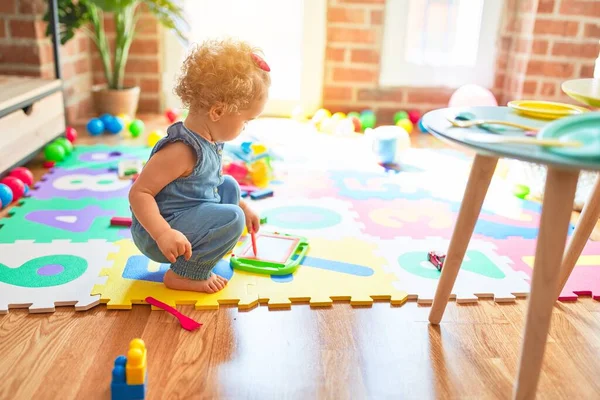 カラフルなプレイルームでおもちゃで遊ぶ美しい白人の幼児 幼稚園で幸せと遊び心 — ストック写真