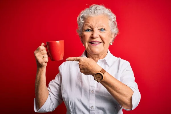 Senior Vacker Kvinna Dricker Mugg Kaffe Stående Över Isolerad Röd — Stockfoto