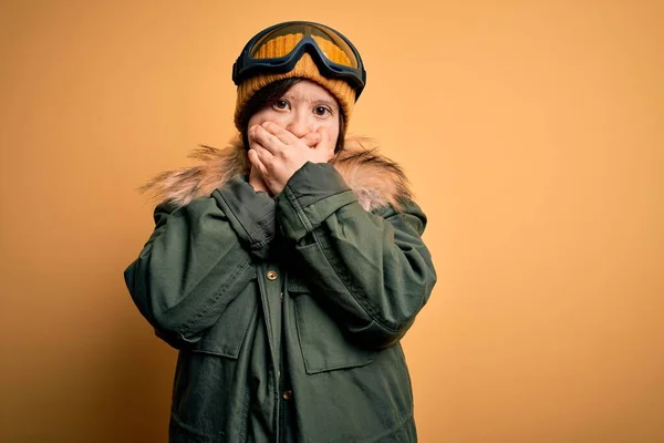 年轻的下意识的女人穿着滑雪外套 戴着眼镜过冬 双手捂住嘴犯错 秘密概念 — 图库照片
