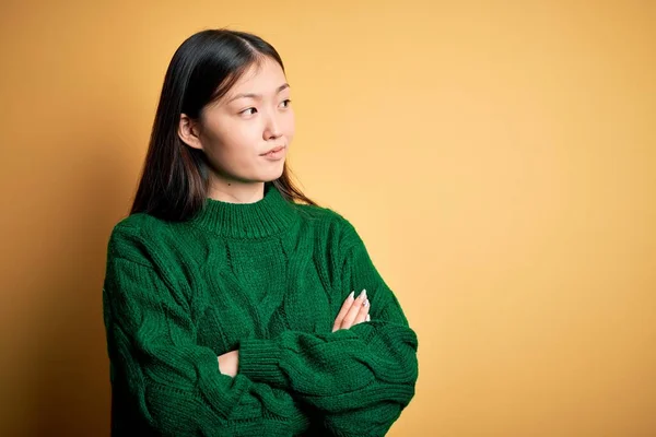 초록색 스웨터를 노란색외진 벌리고 바라보고 아름다운 아시아 여성은 가지고 있었습니다 — 스톡 사진