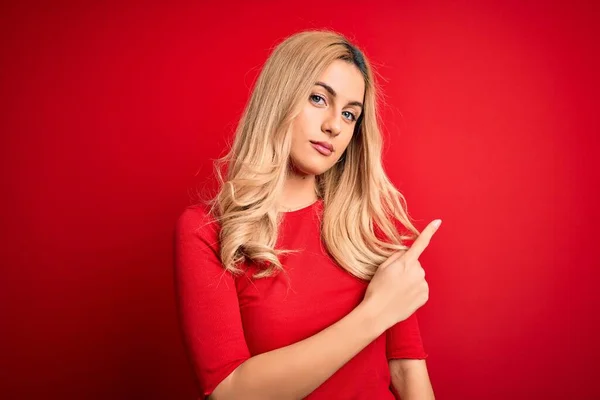 Jovem Mulher Loira Bonita Vestindo Camiseta Casual Sobre Fundo Vermelho — Fotografia de Stock