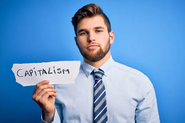 Young Blond Businessman Beard Blue Eyes Holding Paper Capitalism Message — Stock Photo, Image