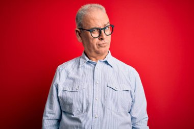 Orta yaşlı, beyaz, sıradan çizgili gömlek giyen, kırmızı arka planda gözlük takan, kuşkucu ve sinirli bir adam. Problemden dolayı surat asıyor. Negatif kişi.