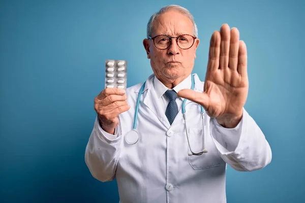 Starší Šedovlasý Lékař Muž Drží Farmaceutické Pilulky Přes Modré Pozadí — Stock fotografie