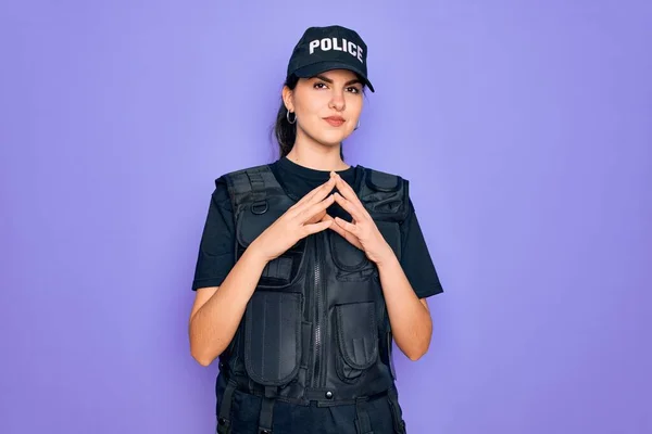 年轻的女警察身穿防弹背心制服 身穿紫色背景的制服 手牵手 手指头交叉 面带微笑 轻松愉快 成功与乐观 — 图库照片