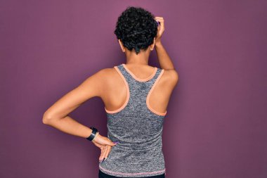 Genç ve güzel Afro-Amerikan Afro-Amerikan spor kadın spor kıyafetleri giyerek spor yapıyor. Geriye doğru geriye doğru, kuşkuları kafa kafaya düşünüyor.