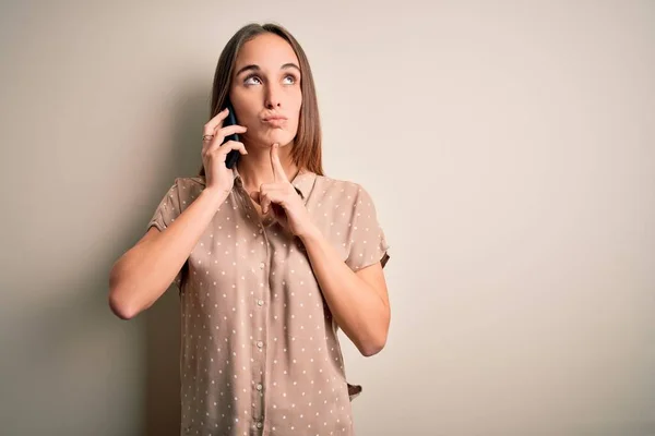 Ung Vacker Kvinna Som Pratar Smartphone Över Vit Bakgrund Funderar — Stockfoto