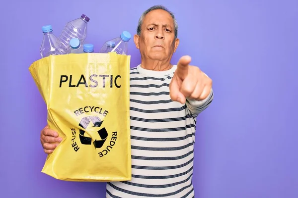 Starszy Człowiek Recyklingu Torba Plastikowych Butelek Recyklingu Fioletowym Tle Wskazując — Zdjęcie stockowe