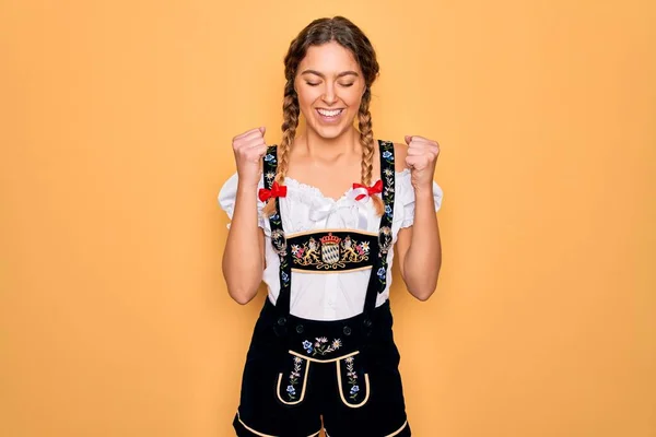 年轻美丽的金发德国女人 蓝眼睛 身穿传统的十月节婚纱 为成功而兴奋 举起双臂 闭目笑着庆祝胜利 赢的概念 — 图库照片