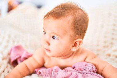 Evdeki kanepede battaniyenin üzerine uzanmış sevimli bir bebek. Yeni doğmuş bebek rahatlıyor ve dinleniyor.
