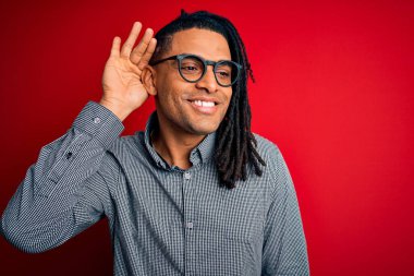 Rastgele gömlek ve gözlük takmış, ağzı kulaklarına varan bir gülümsemeyle dedikoduları ve dedikoduları dinleyen yakışıklı Afro-Amerikan bir adam. Sağırlık kavramı.